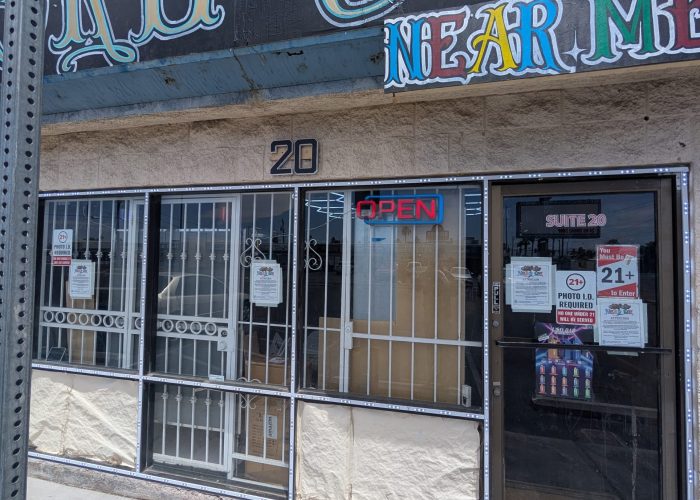 Retail storefront entrance with security bars and signs